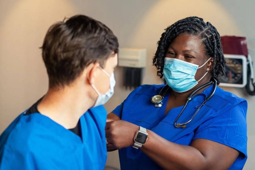a black nurse injecting her patience, nursing jobs