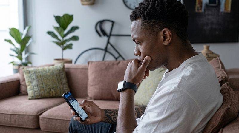 Person checking loan app details on phone to know if a loan app is legit in Nigeria